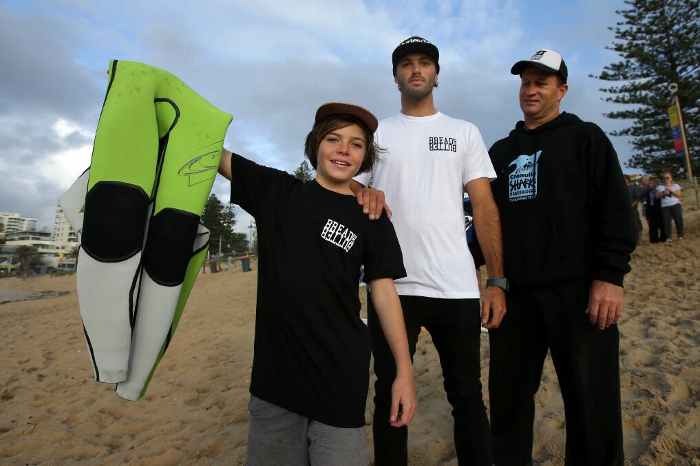 Here you go bro: Surfers Chris Demajo and Cameron Johnston, with high school student Cooper Moores-Sipos, who received a new wetsuit in a random act of kindness. Picture: John Veage