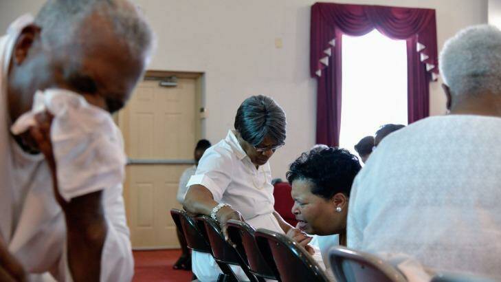 Pastor Jerry Colbert, 64, (left)  the great-grandson of a slave, wipes sweat from his brow as he listens to the prayers of members of a Singing and Praying Band group at the Hall United Methodist Church in Glen Burnie, Maryland.

 Photo: Dermot Tatlow