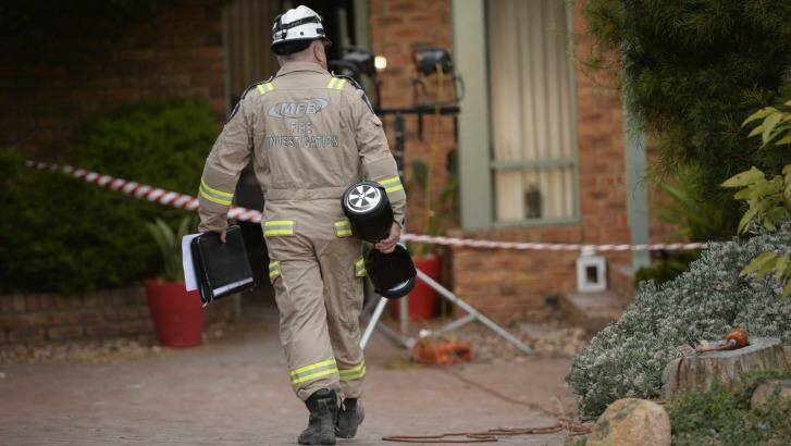 A fire investigator carries a hoverboard of the same make as the one that caused a house fire in Melbourne.  Photo: Justin McManus