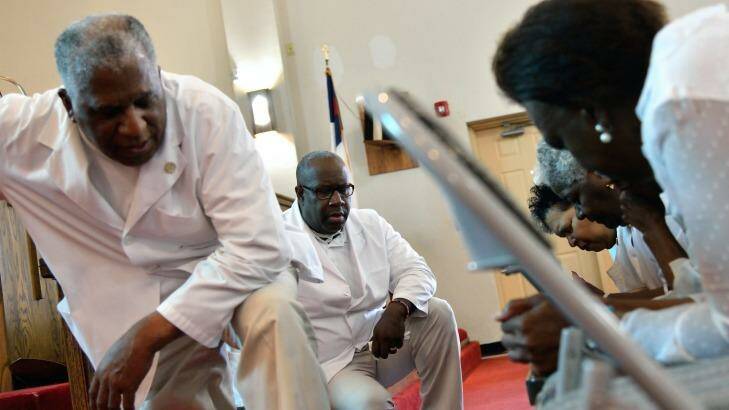 Pastor Jerry Colbert, 64, (left) listens to the prayers of members of a Singing and Praying Band group at the Hall United Methodist Church in Glen Burnie, Maryland.
 Photo: Dermot Tatlow
