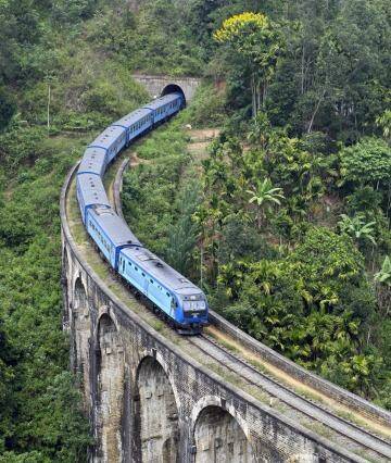 Rail tale: A modern passenger train swoops down over one of Sri Lanka's old bridges.