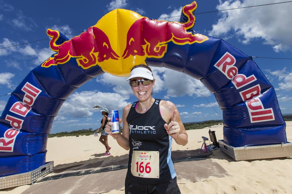 Mum on the run: Mel Campbell celebrates after being the first female to cross the line at the Dune Dusters race at Stockton Beach, NSW. Picture: Red Bull