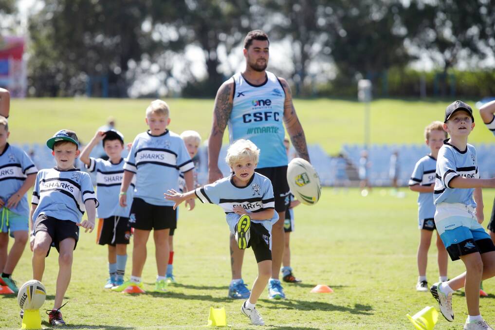 Teaching the skills: Sharks prop Andrew Fifita runs the youngsters through drills at the Junior Jaws clinic. Picture: Chris Lane