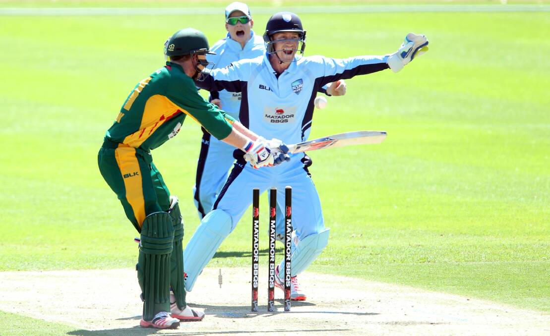 Got him: NSW wicketkeeper Peter Nevill and Steve Smith celebrate the wicket of Ben Dunk. Picture: Chris Lane