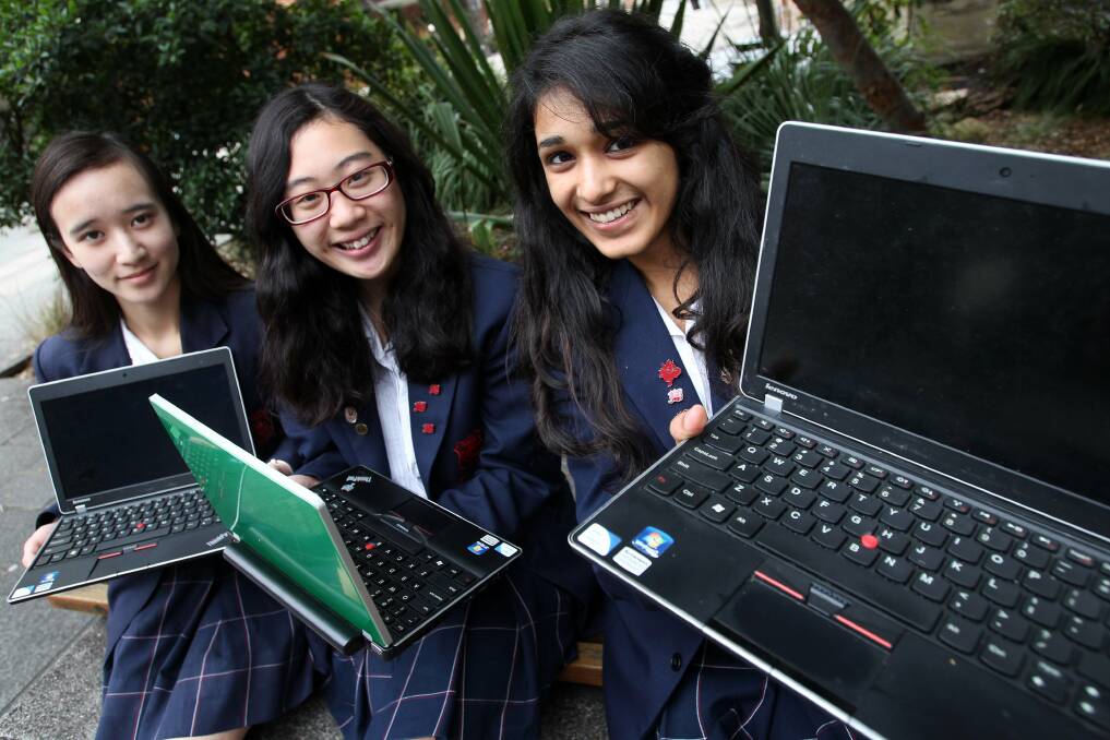 Global purpose: High school students Yatha Jain (right), Ellene Win and Rachel Chan are donating their old laptops to children in need overseas. Picture: Jane Dyson