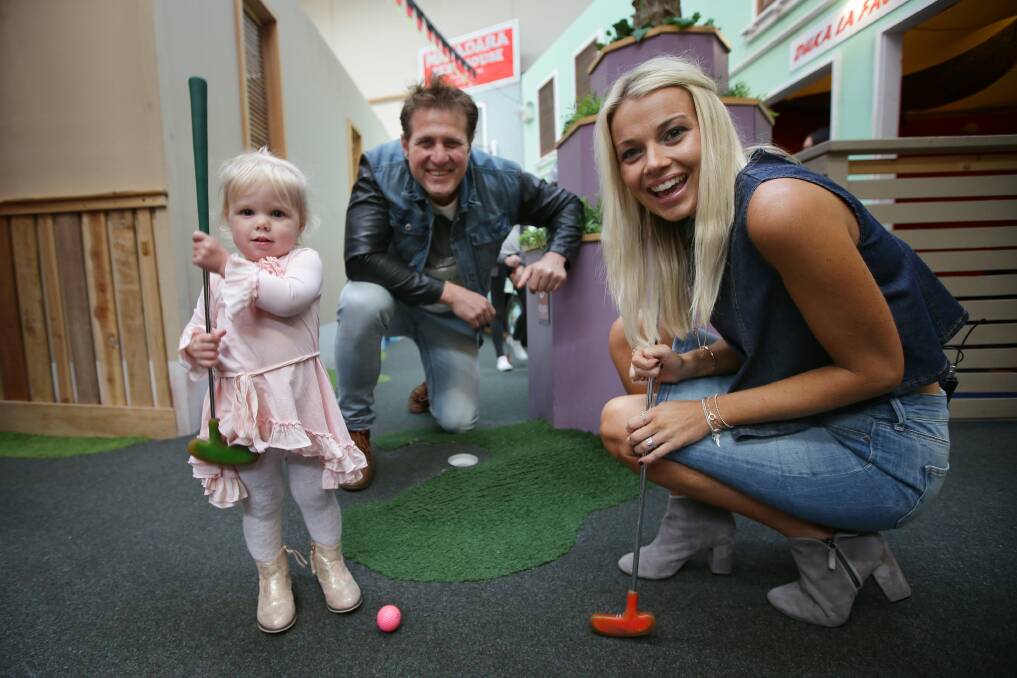 Lights, camera, action: Jason and Bec Stevens with Lyal Bradshaw, 2, at Putt Planet, Miranda. Picture: John Veage