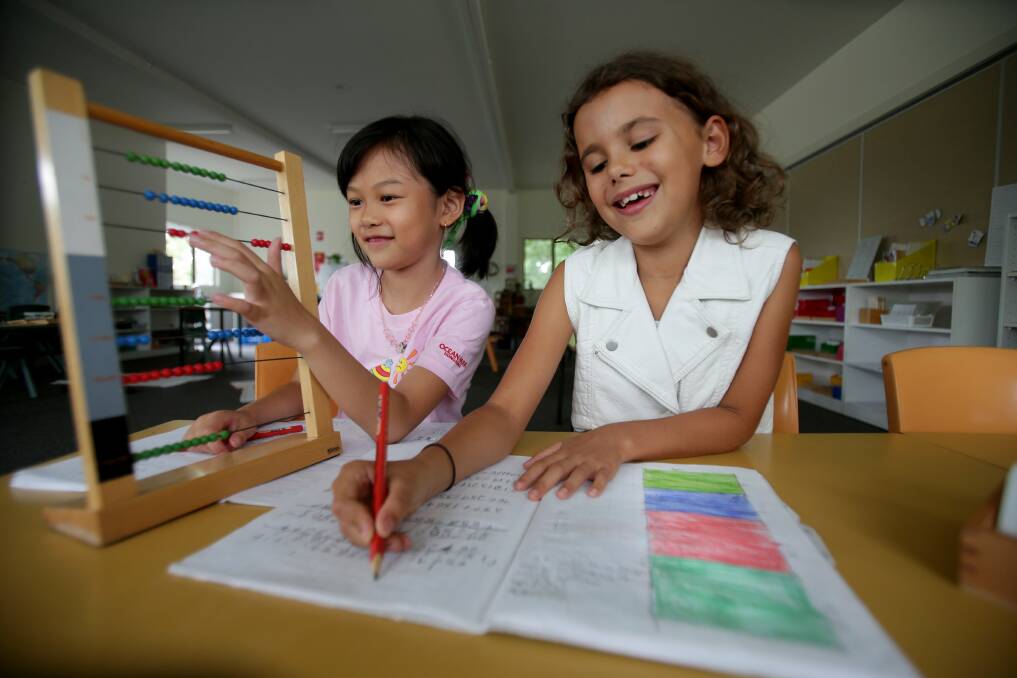 No homework: Alicia Fong , 7, and Deni Ronay Sundin, 8, do their lessons at Sydney Montessori School, Gymea. Picture: Jane Dyson