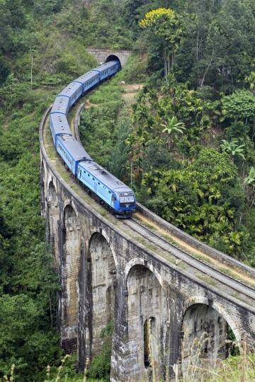 Rail tale: A modern passenger train swoops down over one of Sri Lanka's old bridges.