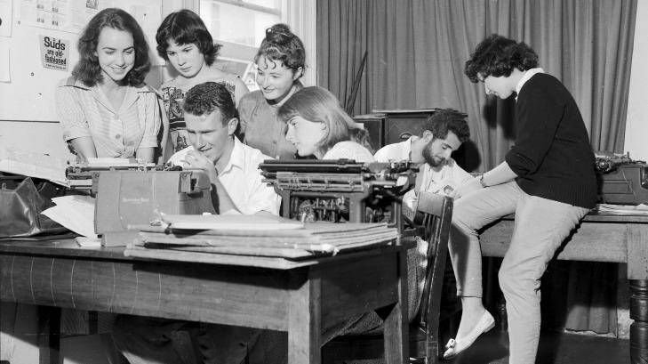 Art students at work preparing the Orientation Week issue of Honi Soit at the University of Sydney. Marie Taylor, Jane Iliff, Madeleine St John and Sue McGowan watch Clive James typing while the editor, David Ferraro, and Helen Goldstein plan other pages, 23 February 1960.  Photo: B. Newberry