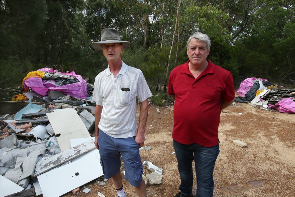 Costly problem: Councillor Peter Towell (right) and Allan Green, of West Menai Action Group, with asbestos dumped at Lucas Heights.