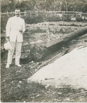 TENNIS COURT UNDAMAGED: The wireless operator who sent the SOS call that brought HMAS Sydney to the area, standing next to the wireless mast destroyed by the German raiding party from the Emden. Photo: Argus Collection, Fairfax Photographic 