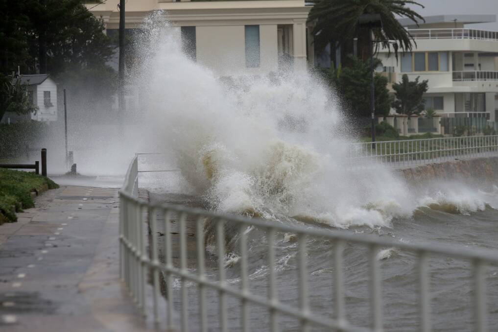 Wild weather: A wave crashes over the walking path and cycle way around Sandringham Bay. Picture: John Veage