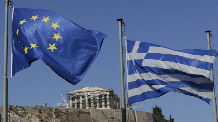 The EU and Greek flags wave under the ancient Acropolis hill in Athens. Photo: Petr David Josek