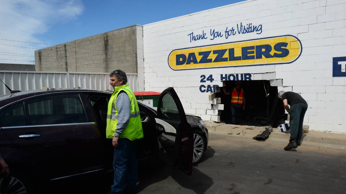 Police help to remove the car from the brick wall at Dazzlers on Mair Street on Sunday. PICTURE: ADAM TRAFFORD