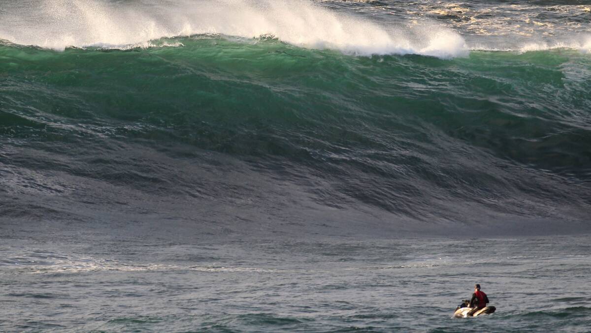 Wave if you can: Surfers check out the waves at Cape Solander. Picture: John Veage