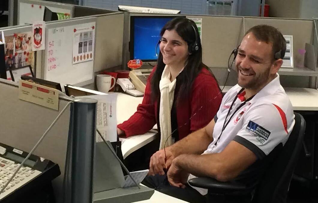 Winning smiles?: Dragons winger Jason Nightingale on the phone at St George Bank, Kogarah. Picture: supplied.

