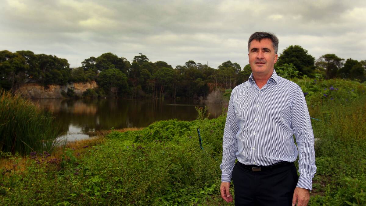 Millions of litres: Chris Ryan is the project director of  the South Village development planned for Kirrawee brick pit. Most of the water at the site (seen in background) will be pumped into stormwater drains. Picture: Lisa McMahon 
