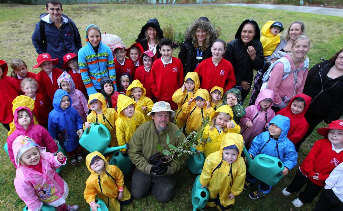 Helping hands: Despite the drizzle, children got their raincoats on and planted trees for national Schools Tree Planting Day. Picture: John Veage.
