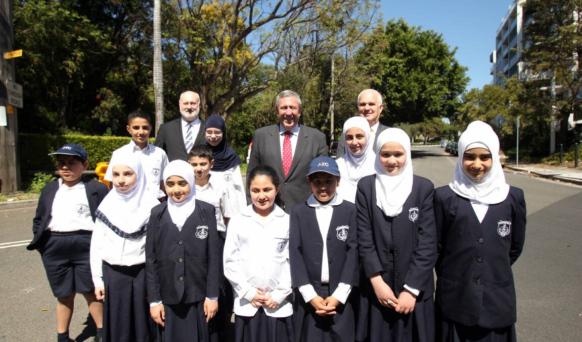 Going it alone: John Flowers (rear left), Duncan Gay and Bruce Handley with Al Zahra College students in front of the rail embankment where the tunnel will be built. Picture: Chris Lane

