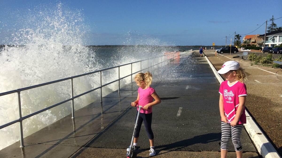 A bit too close: Emerson and Indiana Carroll, of Sans Souci, get sprayed by high tides. Picture: Murray Trembath