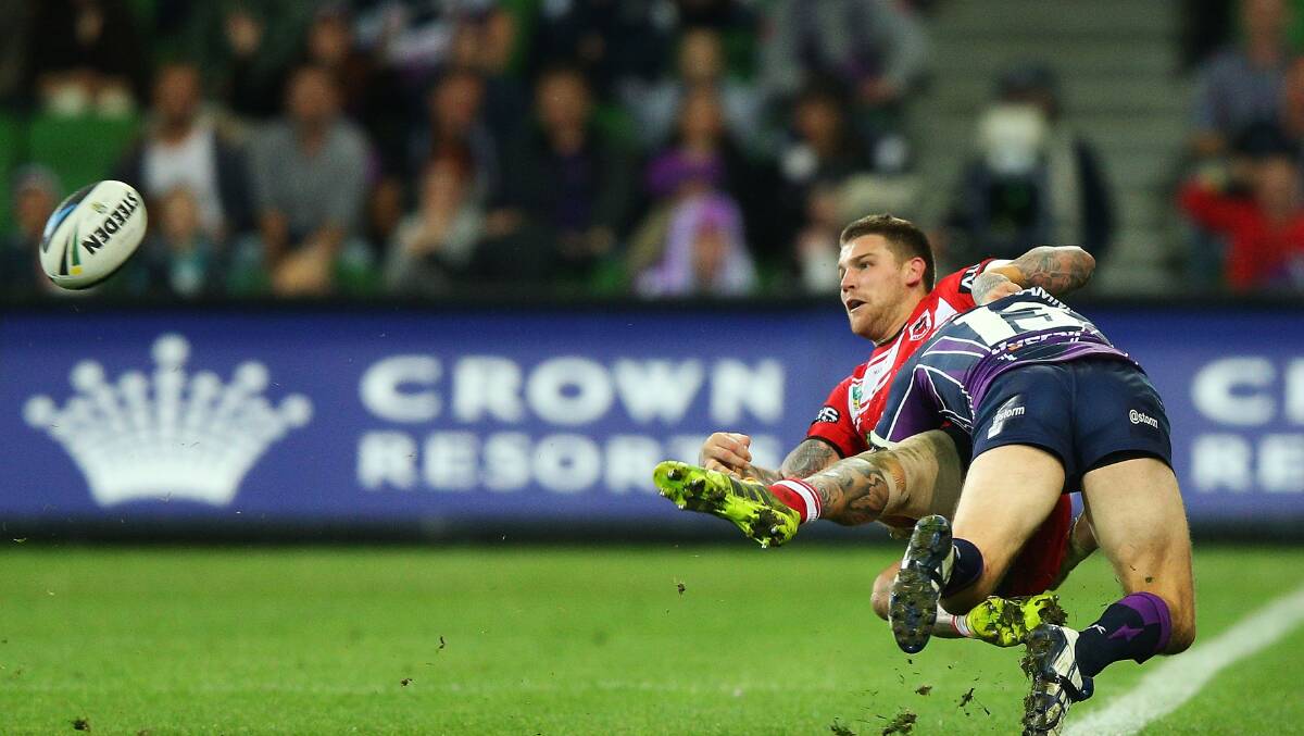 The Dragons Josh Dugan passes the ball while being tackled by the Storm’s Ryan Hinchcliffe during the round 6 NRL game in Melbourne Monday night. Picture: Michael Dodge/Getty Images.

