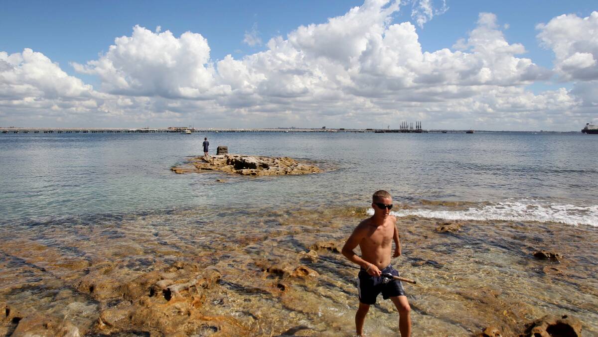 Historic spot: Keiran Watson, of Kirrawee, who regularly fishes from the rock near where the then Lieutenant James Cook stepped ashore in 1770, said the first thing authorities should do was attend to the plaque on the memorial stone.
‘‘It is so corroded by salt, you can hardly read the words,’’ he said. The rock becomes an ‘‘island’’ at high tide. Picture: Chris Lane



