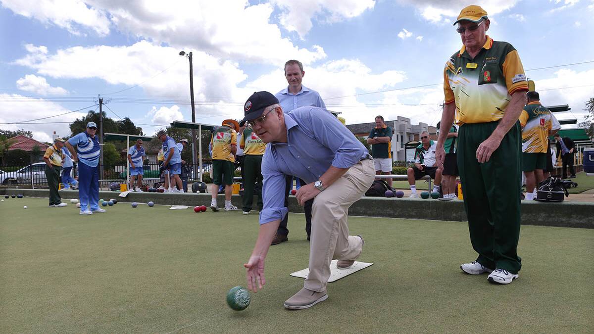 Neville Shaw gives Scott Morrison and David Coleman a lesson in lawn bowls. Picture: Jane Dyson

