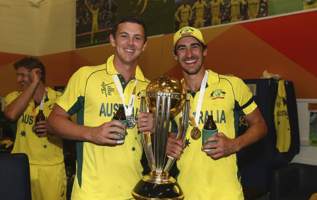 One hand on the World Cup: St George Cricket Club fast bowler Josh Hazlewood (left) with teammate Mitchell Starc celebrating on Sunday after the MCG final. Picture: Ryan Pierse, Getty Images.

