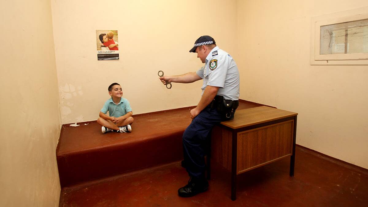 Senior Constable Peter Kench gives little Issac a talking to in the cells. Picture : Lisa McMahon.
