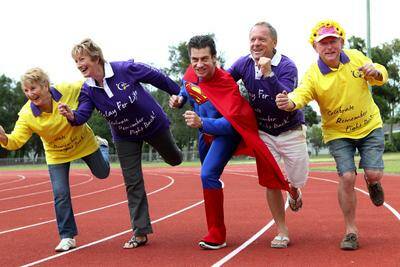 All geared up. Supporters of the Relay for Life limber up: Marion Wood (yellow top) , Kris Shepherd (purple top - hooters), Daniel Mann (superman), , Rod Coy (purple top), Don Wood (hat). Photo: Jane Dyson