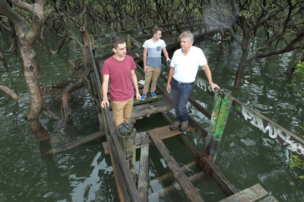 Walking the plank: Aquinas College teacher Jeff Harte with students Kristian Hasapaki and Nick Petrovski, is shocked at the vandalism of Towra Point wetlands boardwalk. Picture: John Veage