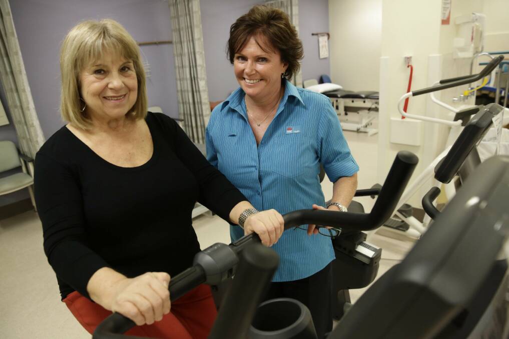 Dollars and good sense: Senior physiotherapist Cathy Brand (right) takes Galina Metlina through some gentle exercises. Picture: Anna Warr