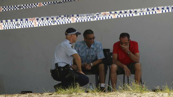 Police talk to the father (right) of missing 5 year old Ayman Ksebe near the George's River sailing club in Sandringham. Photo: Kate Geraghty
