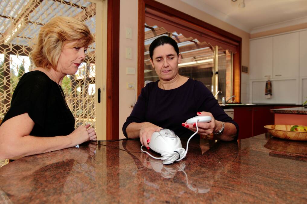 Where there's smoke: Interpreter Fran Collins (right) explains the new smoke alarm to consumer Carleeta Manser.