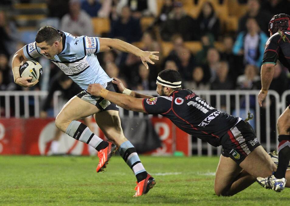 Michael Gordon of Cronulla Sharks escapes a tackle from Warriors Ben Matulino. Pictures: Fiona Goodall/Getty Images