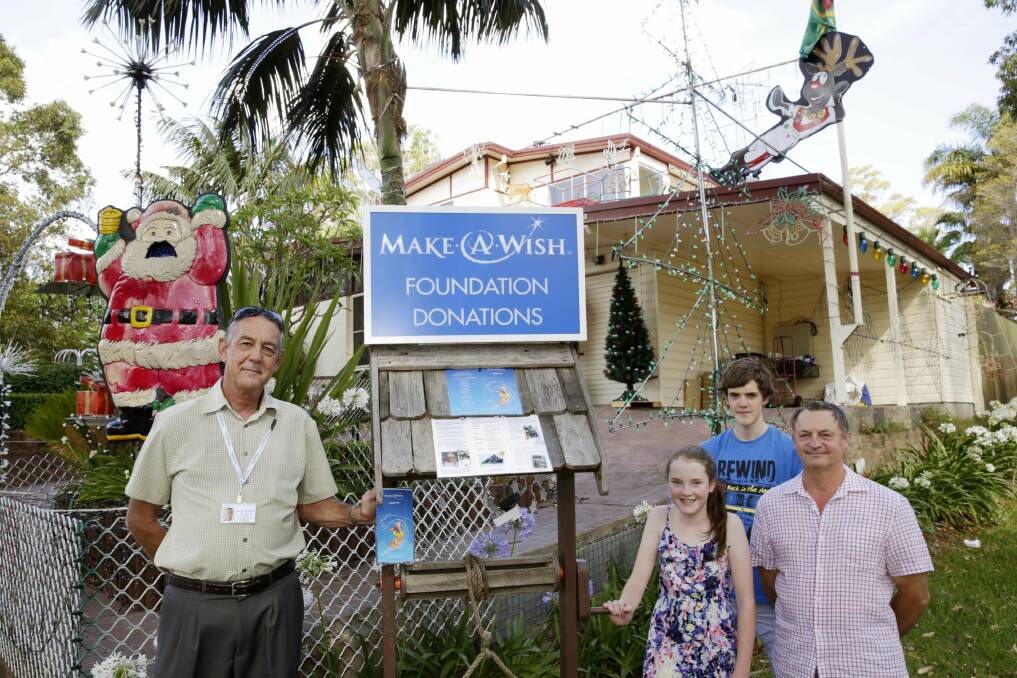 Christmas wish: Make-A-Wish volunteer John Bestel and Allambie Avenue residents Greg Young, Brendan Conneely and Sophie Conneely hope the Christmas lights in their street (pictured right) will encourage donations to help seriously ill children. Picture: Anna Warr