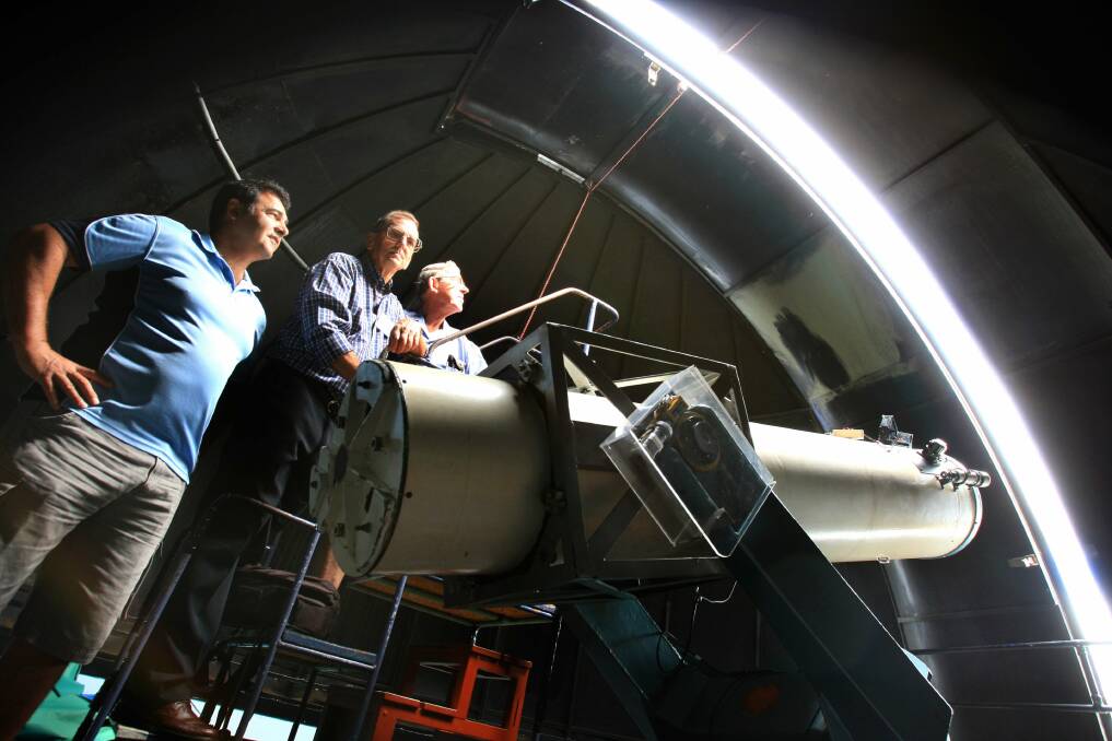 Let there not be light: Astronomical society members (from left) Rolando De Michiel, Vic Audet and Society president Lou Pagano in the dome with one of their two telescopes. Picture: James Alcock