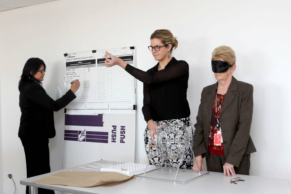 Final field: (left to right) Returning officer for Cook Delia Kapene and Australian Electoral Commission staff member Ashleigh Wilkinson watch fellow AEC staff Barbara Hanley drawing the order of candidates for the ballot. Picture: Lisa McMahon