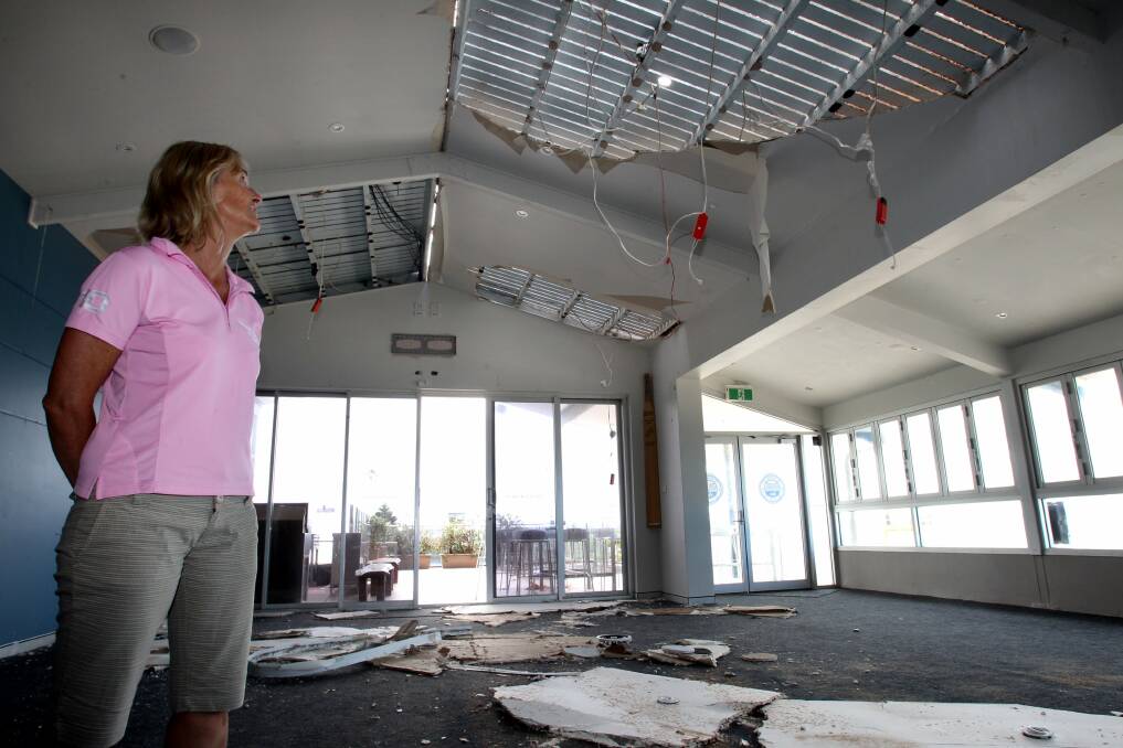 Sad scene: Wanda Surf Life Saving Club president Anita Pryke surveys the damage after wild winds ripped off part of the club’s roof on Saturday. Pictures: Jane Dyson