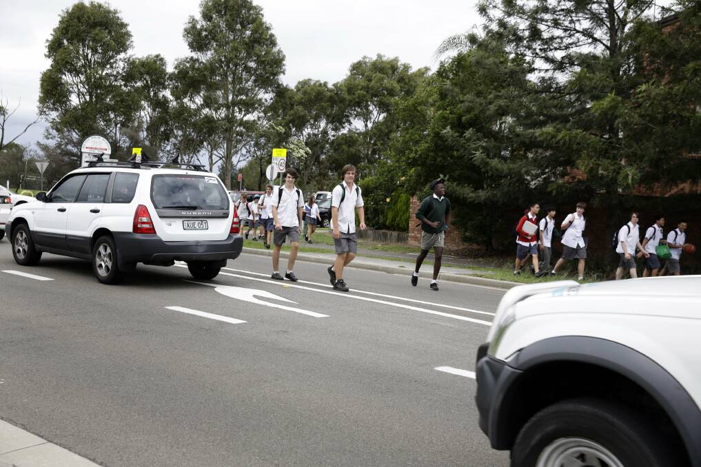 Nightmare crossing: Students cross a busy section of road near Menai High School less than 24 hours after a girl was hit by a car in the same location. Picture: Anna Warr