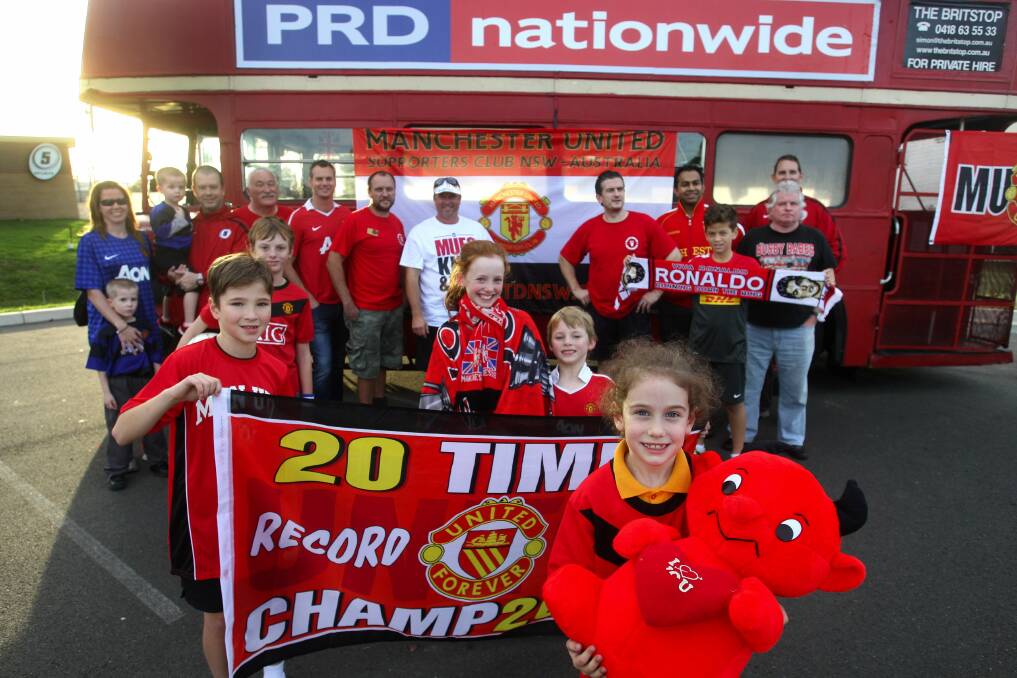 Red devils: Young and old Manchester United fans decorate the red double-decker bus in anticipation of their ride from Sutherland Shire to the city to support the stars of the visiting Manchester United club. The team arrives in three weeks for their one-off game against an Australian All Stars team at Sydney’s ANZ Stadium. Picture: John Veage