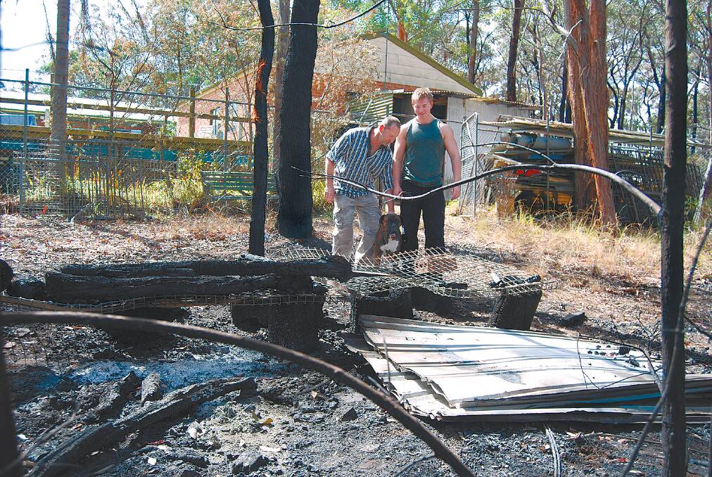 Father and son Steve and Josh Jones inspect the bushfire damage to their Hawkesbury Road property on Friday. “We won’t need hazard  reduction for a while,” Josh said.