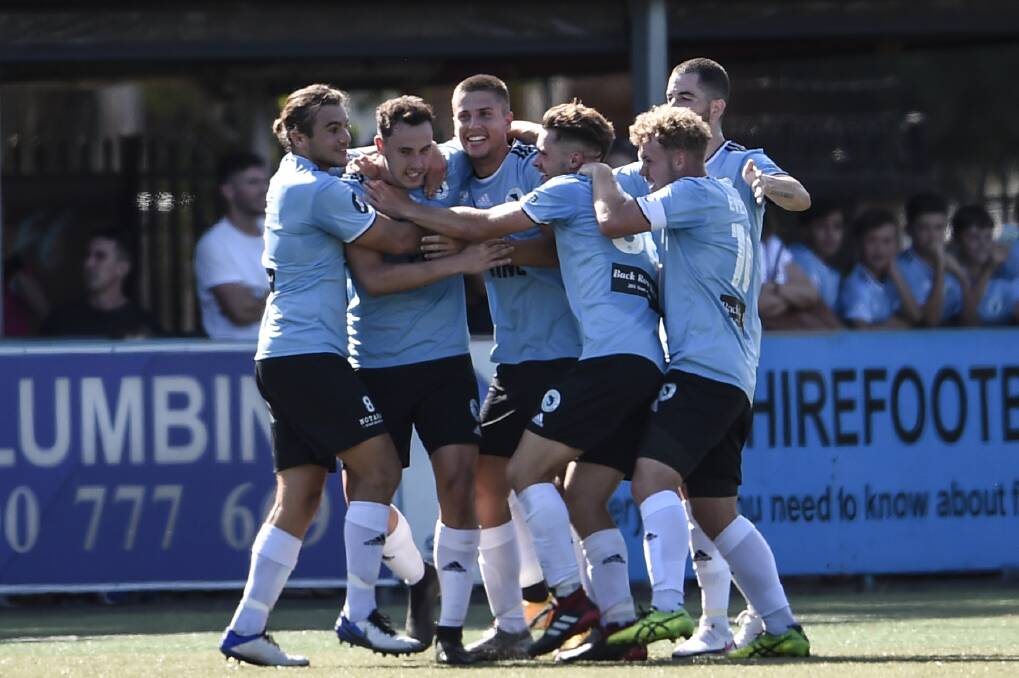 Draw: The Sutherland Sharks gather around Gabriel Contigiani after he slotted the teams only goal in their 1-1 match against the Marconi Stallions. Picture: Football NSW