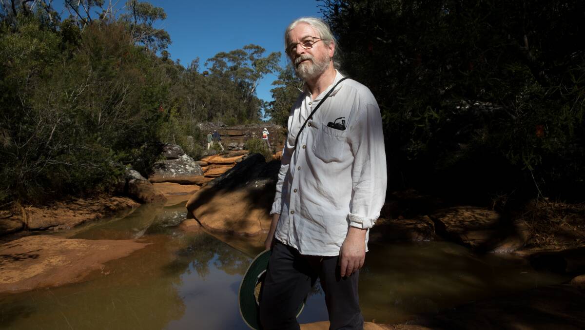 Peter Turner, from the National Parks Association of NSW, examines iron contamination of the Eastern Tributary, in the Woronora catchment area. Picture: Janie Barrett