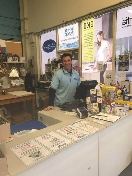 SERVICE WITH A SMILE: Manager Brent Pallister behind the counter and ready to offer advice.