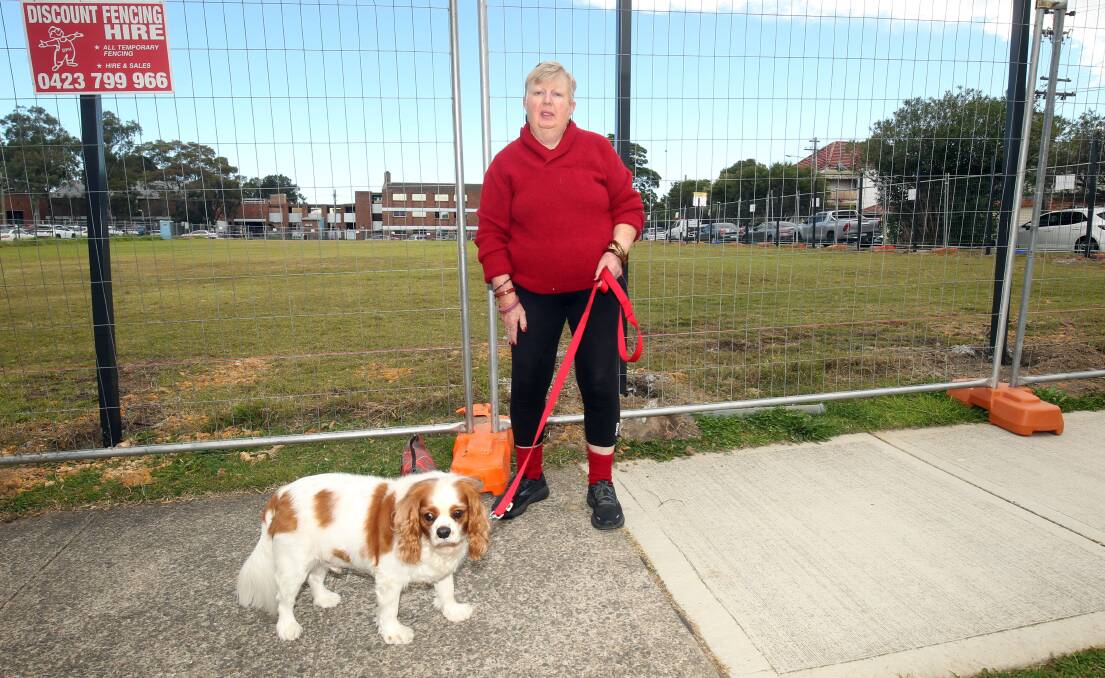 Anne Field with Teddy outside the fenced-off Kogarah High oval which has been accessible to the community for decades. Picture: Chris Lane