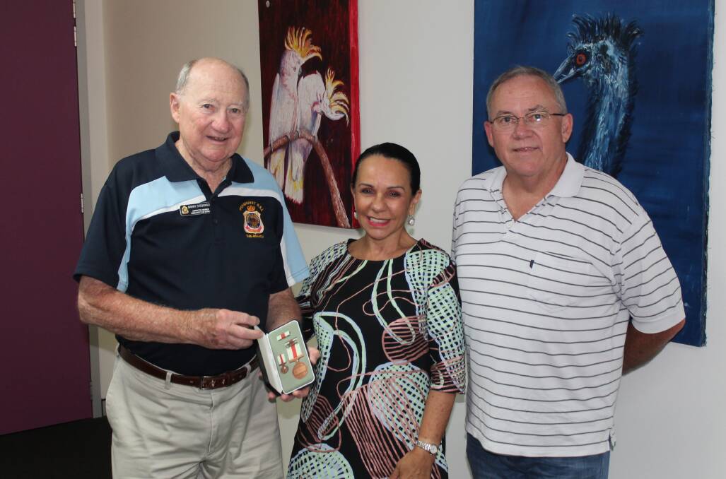 Legacy honoured: from left, Barry Stevenson with his father's WWII Civilian Service Medal, Barton MP Linda Burney, and Barry's son Bryan.