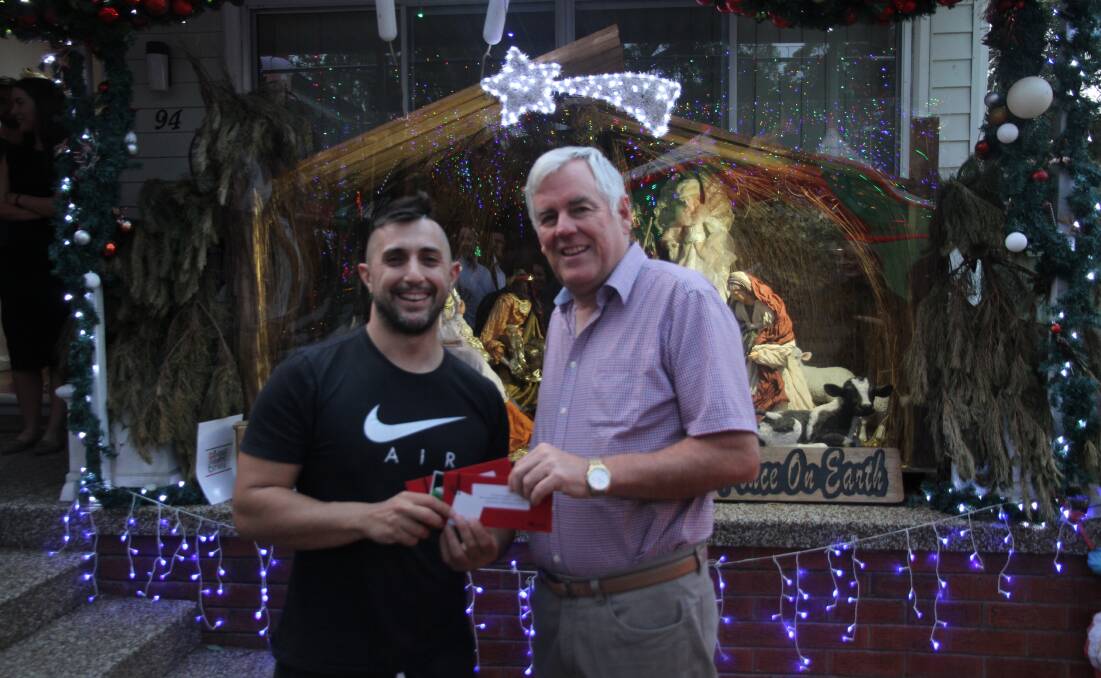 Georges River Council mayor Kevin Greene (right) congratulates the overall winner of the Christmas Lights competition was Sam Panagakis for his display at Lorraine Street, Peakhurst Heights.