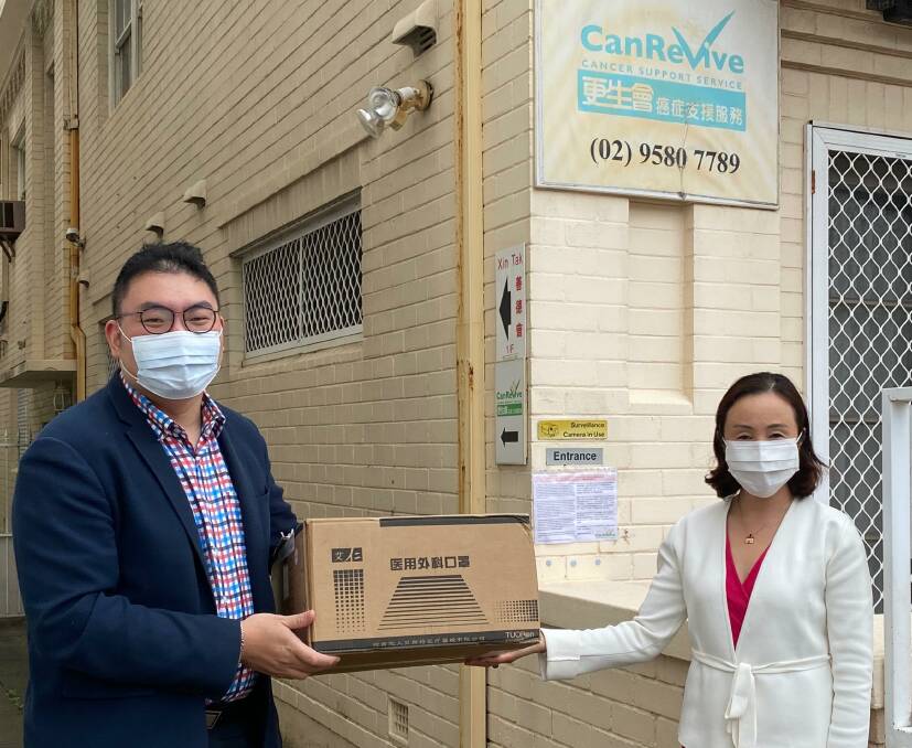 CanRevive pandemic officer Victor Yeung accepts the 500 free face masks from Georges River Councillor Nancy Liu outside CanRevive's Hurstivlle office.