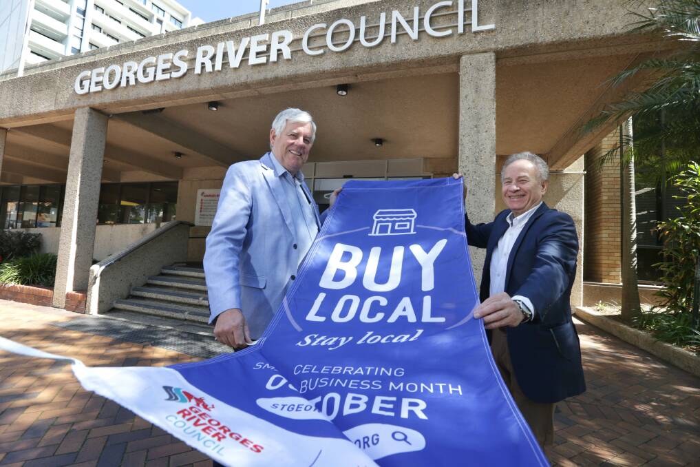 Spreading the message: Georges River Council mayor Kevin Greene and St George Business Chamber president Allan Zreik unveil one of the new Buy Local Stay Local banners. Picture: John Veage